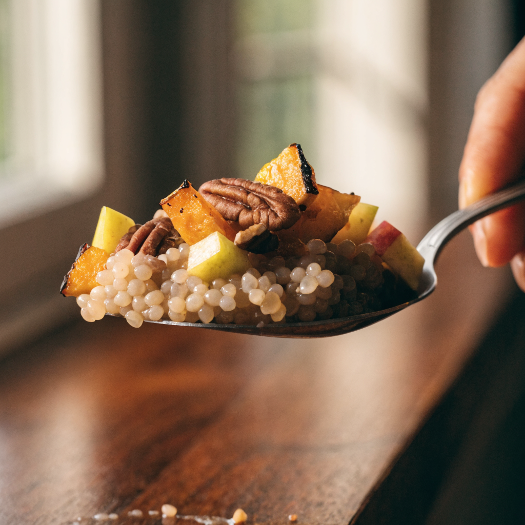 Close-up of autumn pearl couscous salad with roasted squash and maple-mustard dressing